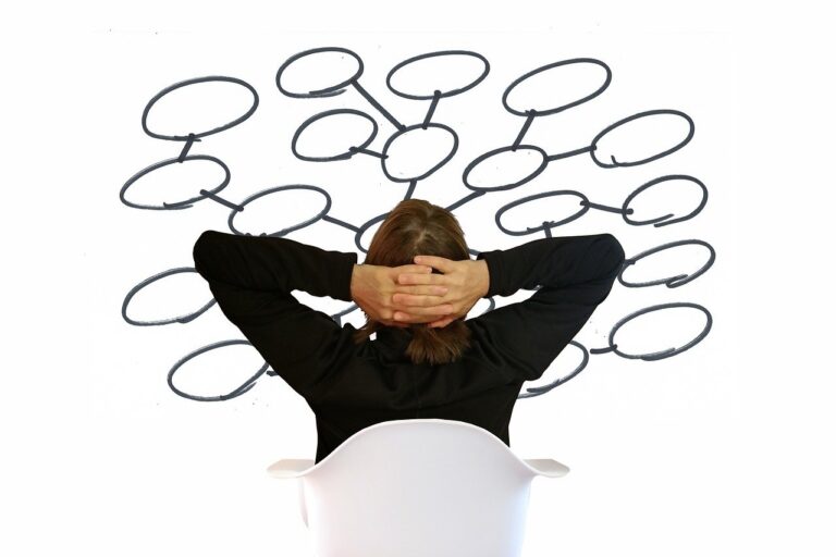 Kobieta z rękami założonymi za głowę próbuje znaleźć sposoby na natłok myśli.